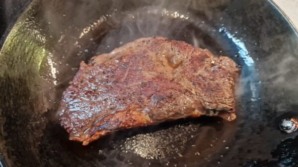 Sirloin steak in smoking hot pan