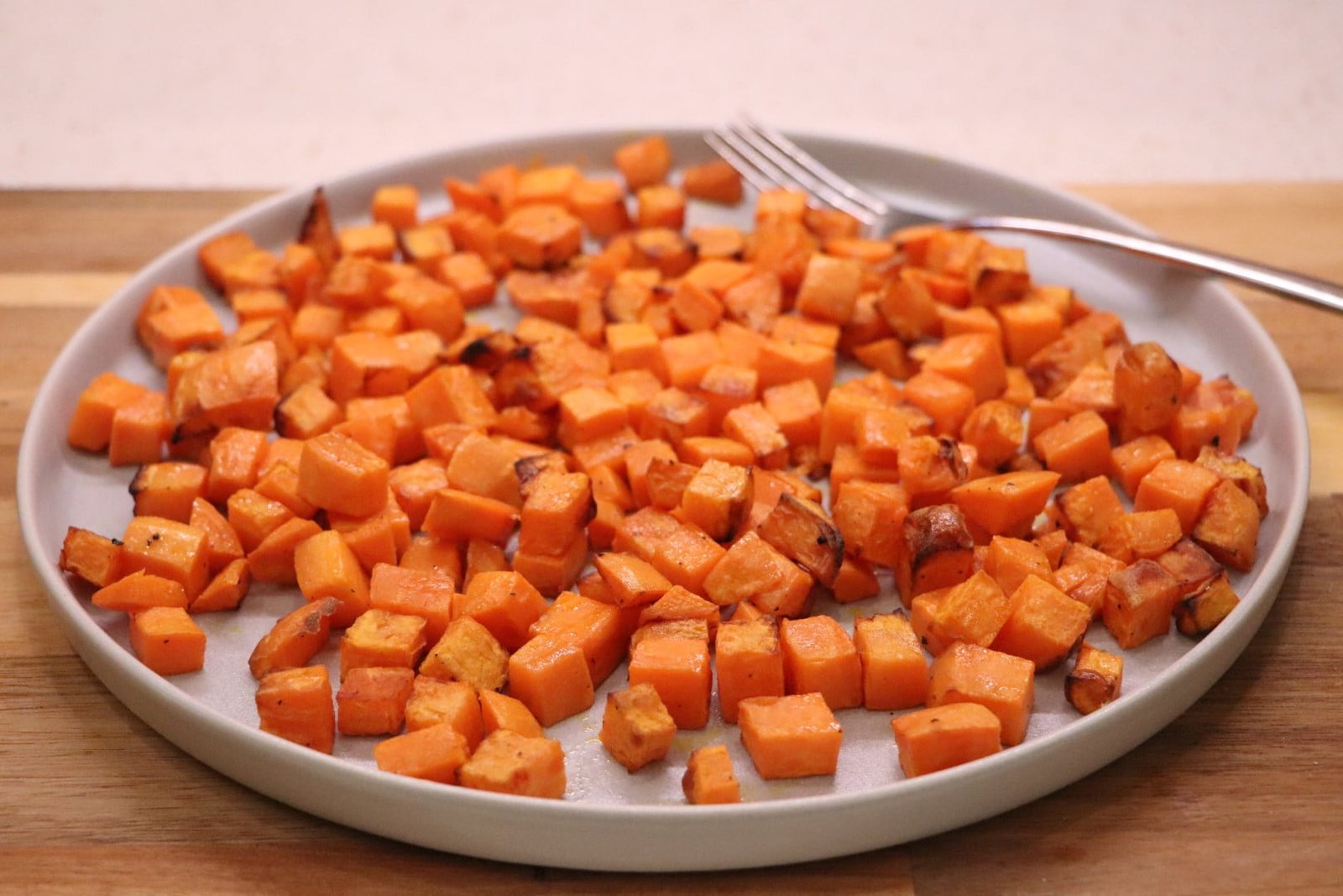 Baking sweet potato cubes in an airfryer on a plate