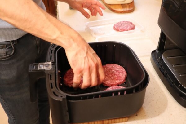 hamburger meat patties in airfryer inserting meat patties
